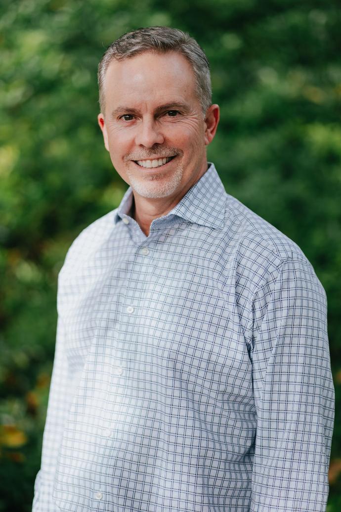 smiling man wearing white and blue dress shirt